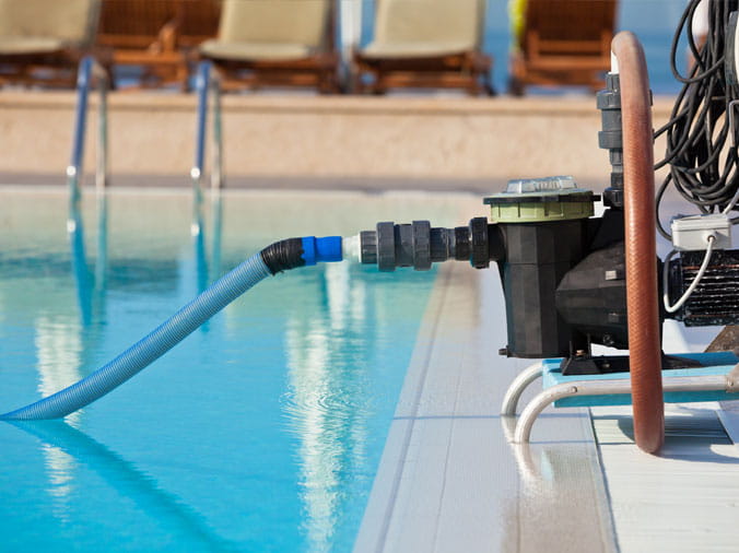Pool vacuum on the side of a swimming pool